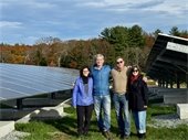 Select Board Members and Town Administrator stand in front of solar panels at the Lincoln Transfer Station.